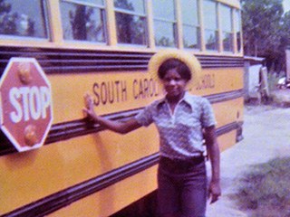 Joyce de pie junto al autobús que conducía en la escuela secundaria